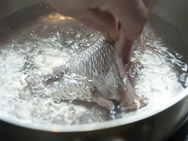 魚のアラを熱湯に入れる