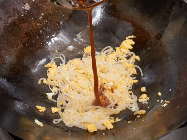 米麺を加えて強火で炒め、合わせ調味料で味をつける