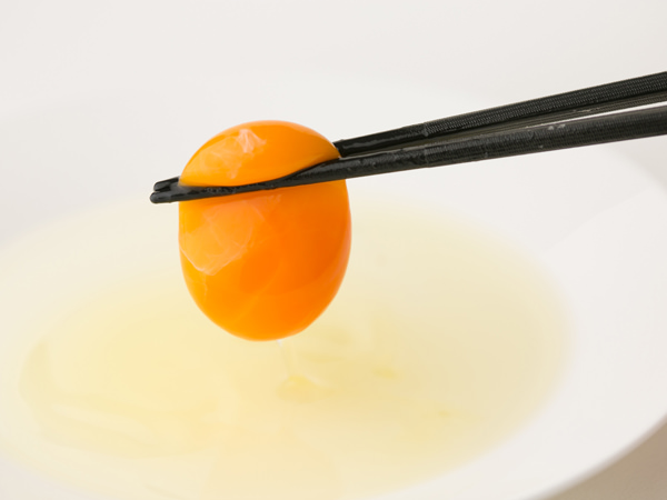 イセ食品の伊勢の卵赤玉の黄身を箸で持ち上げたところ