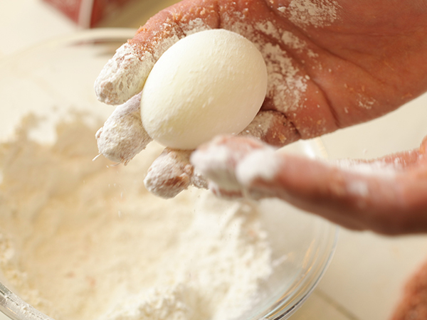 ゆで卵に小麦粉をつけるところ
