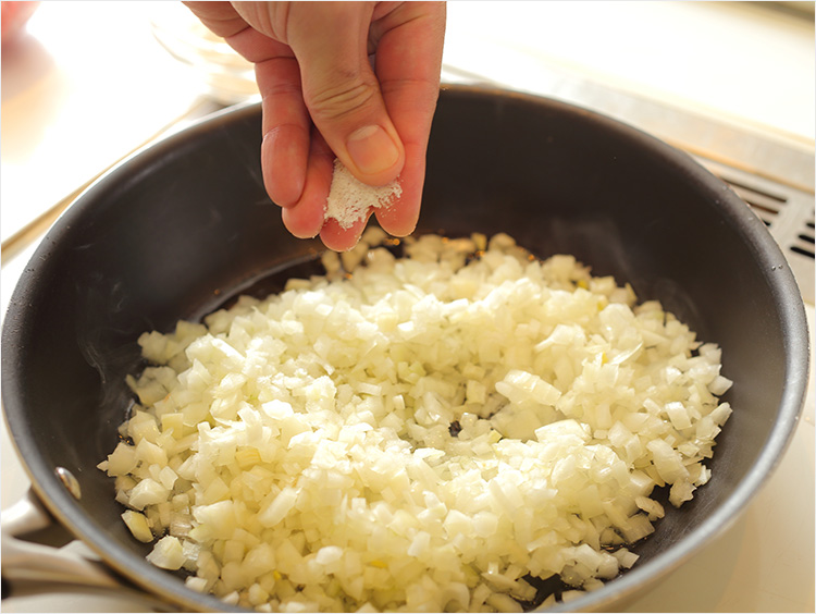 玉ねぎのみじん切りにひとつまみの塩を加えるイメージ