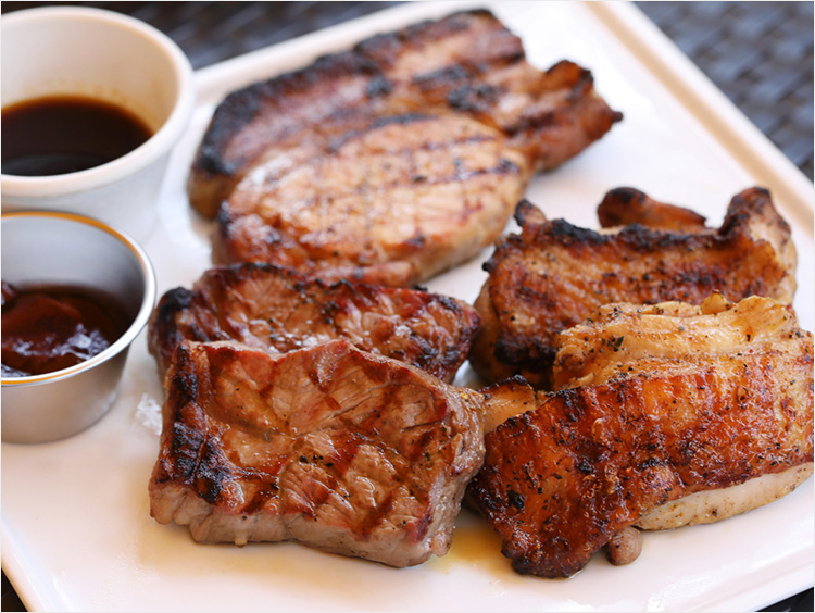 焼き上がった肉にBBQソースを添えた様子