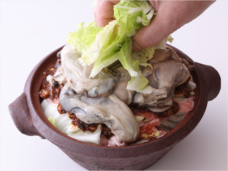 牡蠣に白菜の葉をのせるイメージ