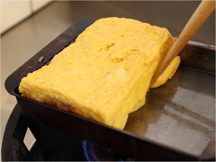 玉子焼きを奥に押しあてて焼き色をつけるところ