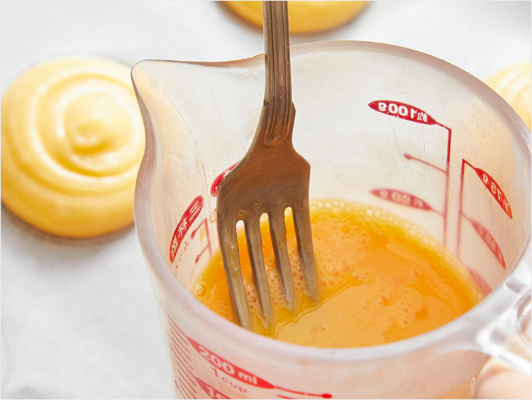 溶き卵にフォークを浸すイメージ