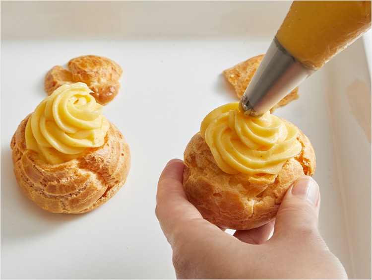 シューにクリームを絞り出すイメージ