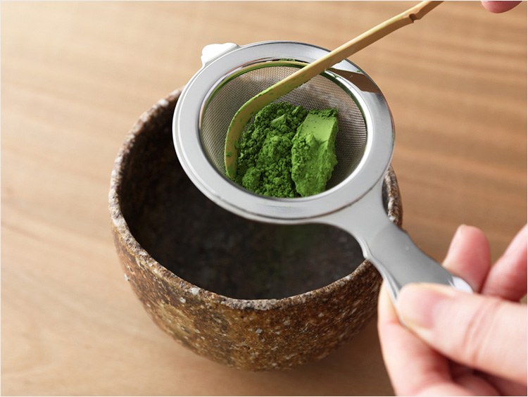 茶漉しと茶杓で抹茶を漉す様子