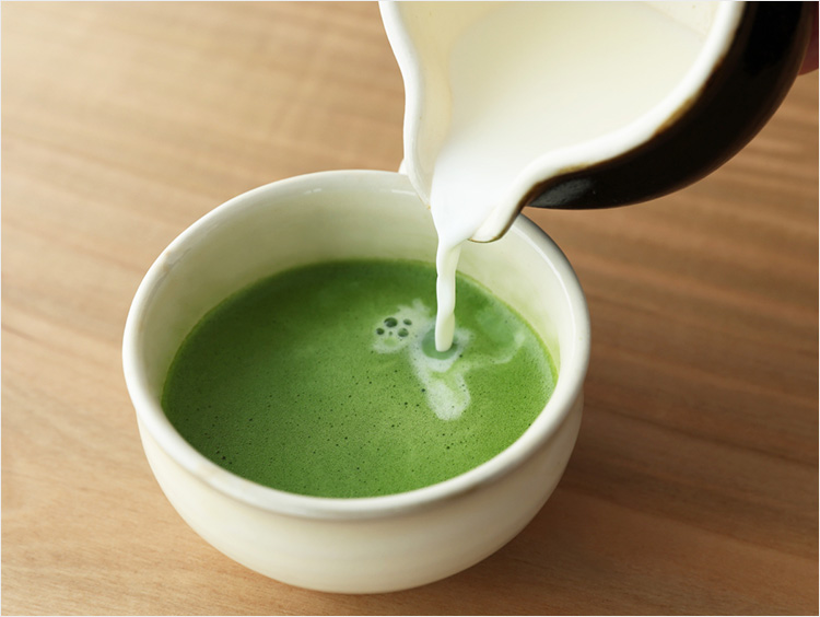 薄茶に温めた牛乳を注いで、抹茶ラテを作る様子